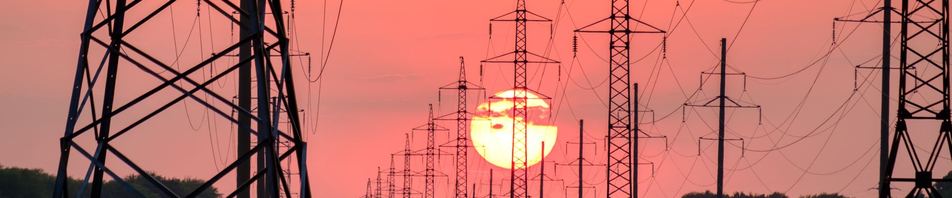 Electricity pylons in front of sunset